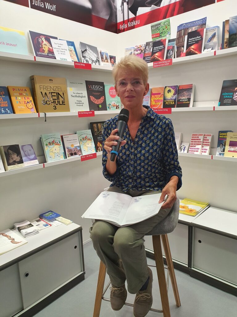 Foto von Maria Brand auf der Buchmesse 2022 bei der Lesung aus ihrem Buch Pusteblume